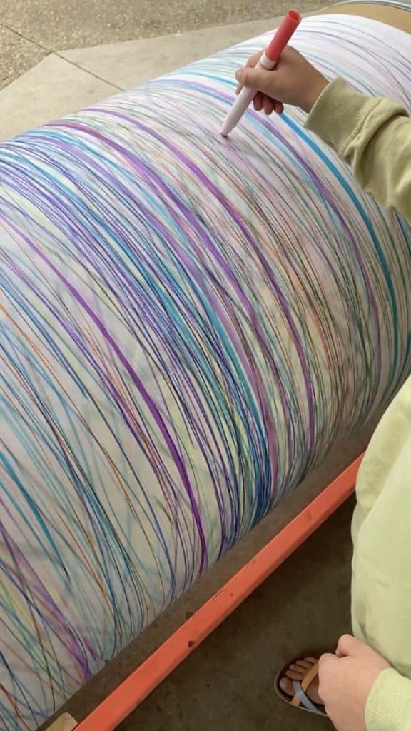 DIY giant spinning art barrel for kids made from a 55-gallon fiber drum